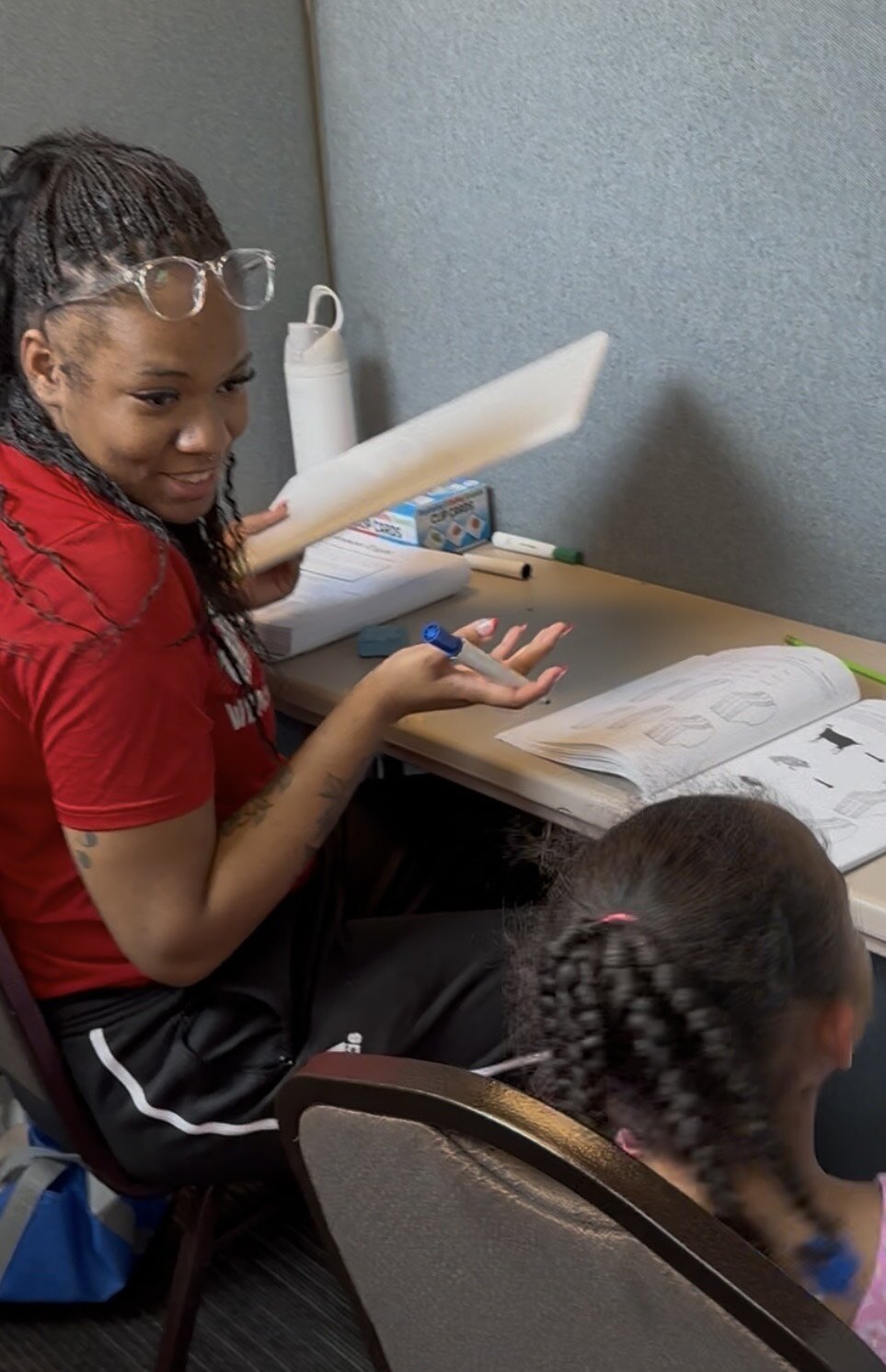 A volunteer works with a young student who is working to reach a higher reading level.